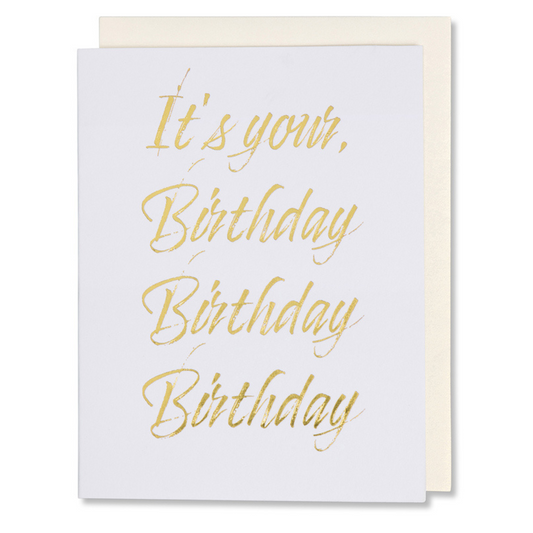 Modern birthday card with gold foil lettering reading 'It's Your Birthday Birthday Birthday' on white paper with gold foil shown with white gold metallic envelope
