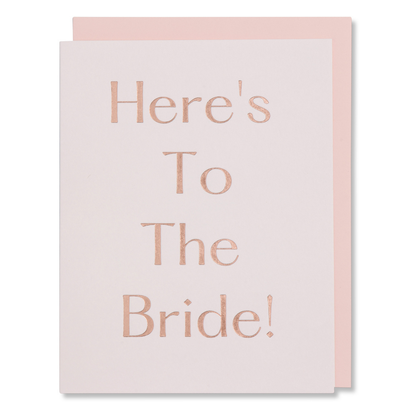 Bridal shower card with rose gold foil on light pink paper, reads 'Here's To the Bride,' elegant and feminine, shown with matching blush envelope