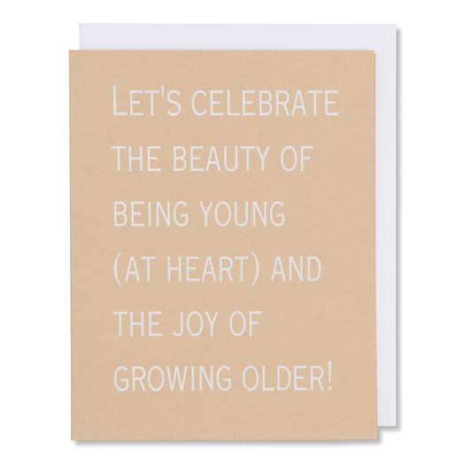 Card reads 'Let's celebrate the beauty of being young (at heart) and the joy of growing older,' ideal for birthday or anniversary, shown with matching white envelope. white foil stamped.