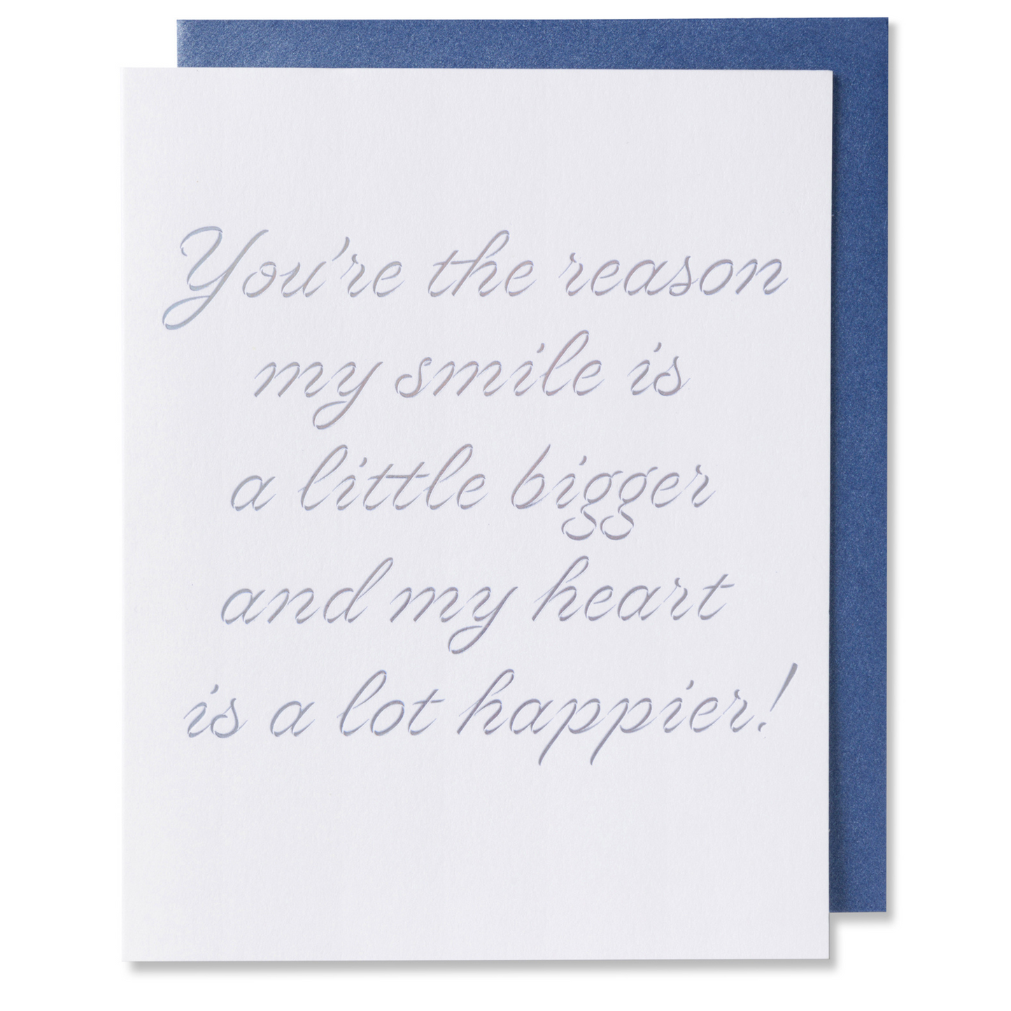 Letterpress romantic love card with You're the reason my smile is bigger and my heart is a lot happier!  On white paper with silver foil stamped. Metallic blue envelope