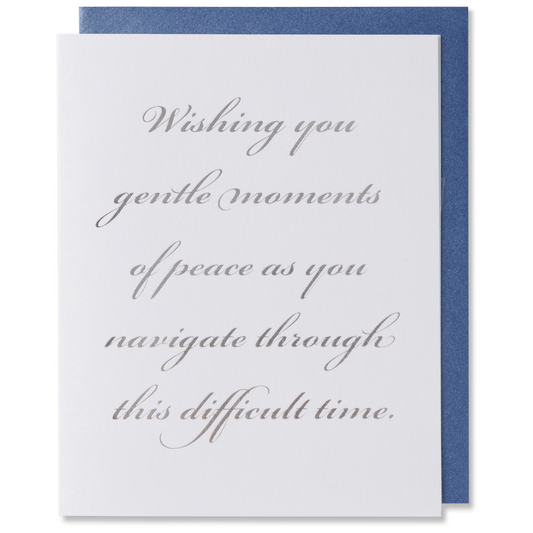 Sympathy card with silver foil on white paper, reads 'Wishing you gentle moments of peace as you navigate through this difficult time,' shown with metallic blue envelope