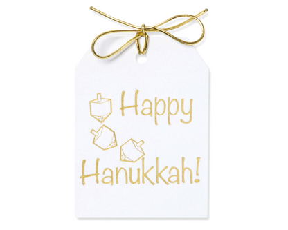 Gold foil Happy Hanukkah!, with an iImage of a dreidel gift tag in gold foil on white linen paper. with a gold metallic tie.3.5x4.5"